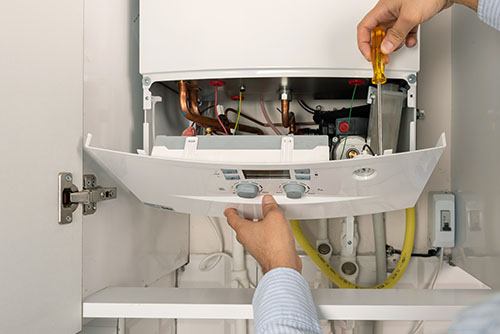HVAC technician repairing an indoor boiler in Ogden