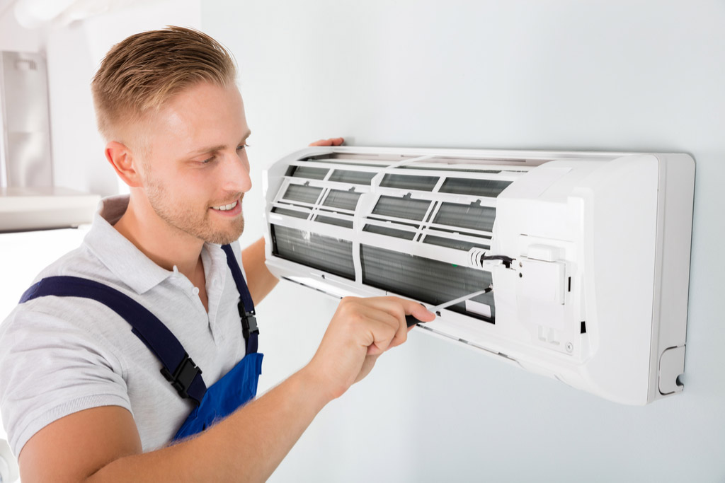 HVAC technician performing ductless air conditioning maintenance in Ogden