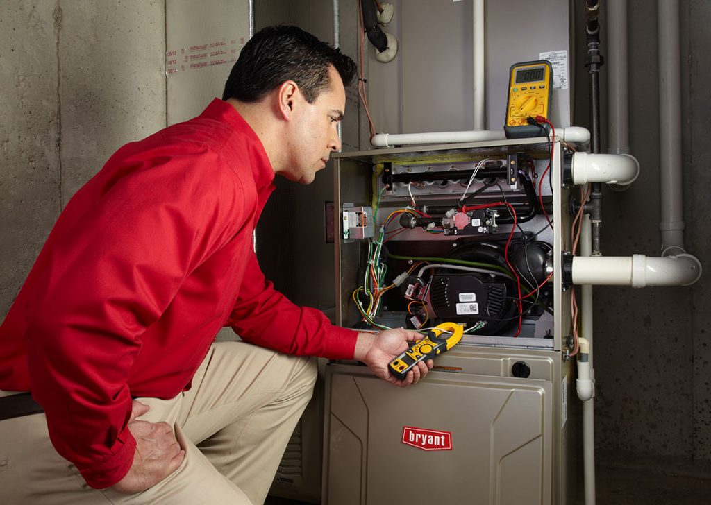 HVAC technician repairing an indoor furnace in Ogden