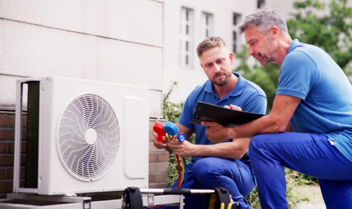 HVAC technicians installing an outdoor air conditioning unit in Ogden