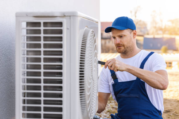 HVAC technician servicing an outdoor air conditioning unit in Ogden