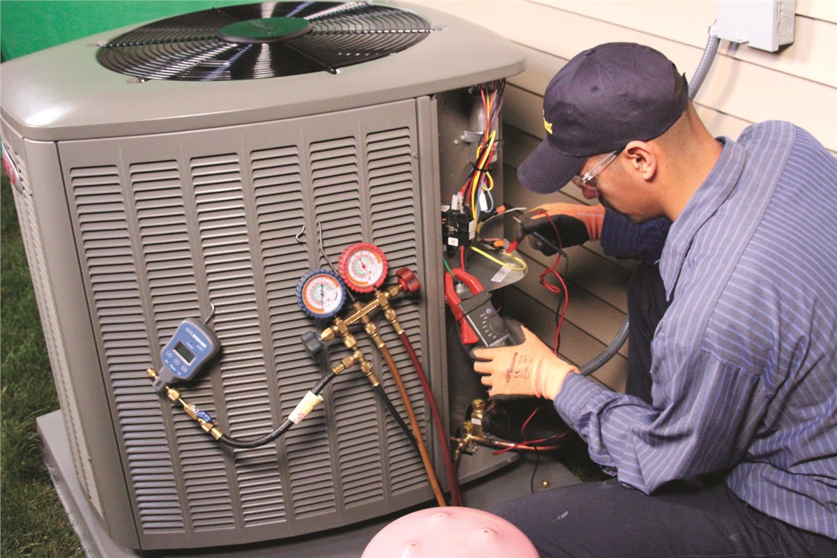 HVAC technician testing an outdoor air conditioning unit in Ogden