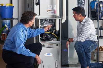 HVAC technician explaining furnace repair and maintenance to a homeowner in Ogden, UT