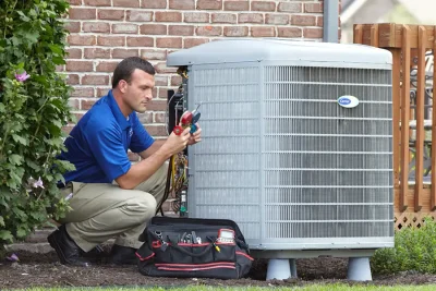 HVAC technician inspecting an outdoor air conditioning unit in Ogden, UT